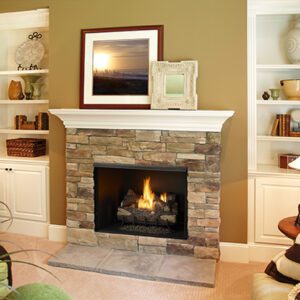 Stone fireplace with burning fire and shelves.