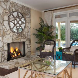 Cozy living room with stone fireplace and chairs.
