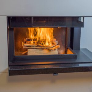 Modern fireplace with burning wood inside.