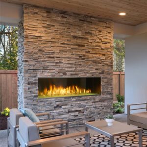 Outdoor patio with stone fireplace and seating.